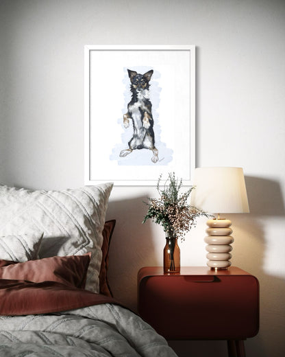 Framed pet portrait of Bruno in a white frame, hung above a bed.