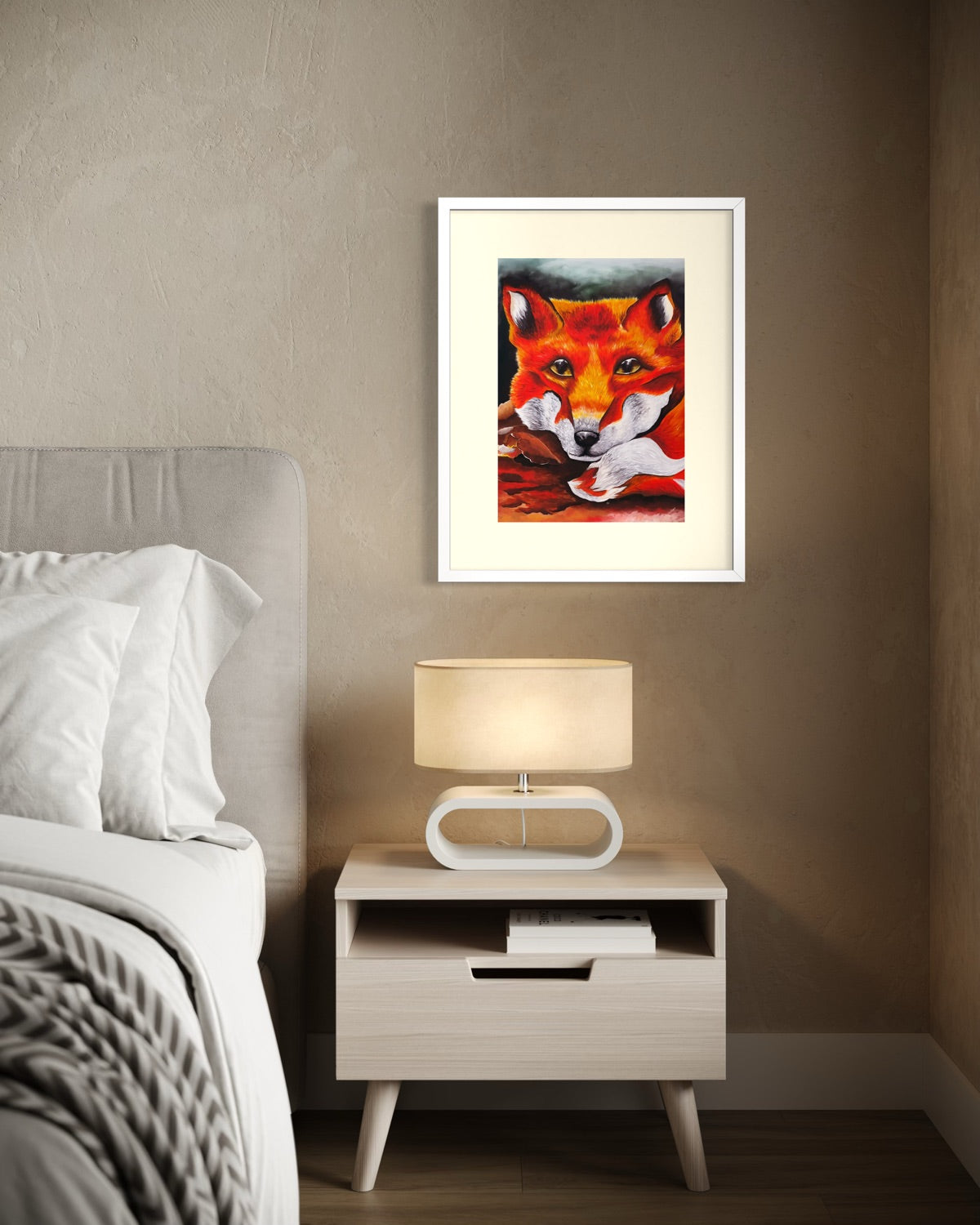 White framed A3 red fox painting on a warm taupe plaster bedroom wall above a midcentury bedside table with an oval ring lamp.