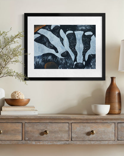 Black framed A2 badger painting on a cream limewash wall above a driftwood console with blossom branches in glass and a stoneware bottle.
