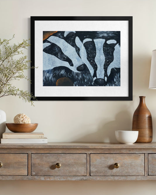 Black framed A2 badger painting on a cream limewash wall above a driftwood console with blossom branches in glass and a stoneware bottle.