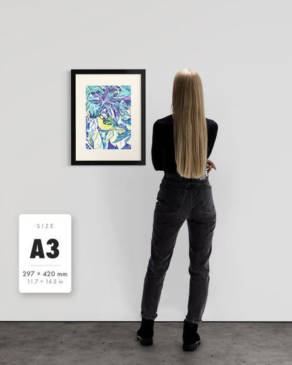 Andrea Nicole 'Taking Flight' blue tit art print in a black A3 frame shown to scale beside a standing woman on a gallery wall, with an A3 (297 × 420 mm) size label. | an:family=print;role=sizeref;size=A3;finish=black