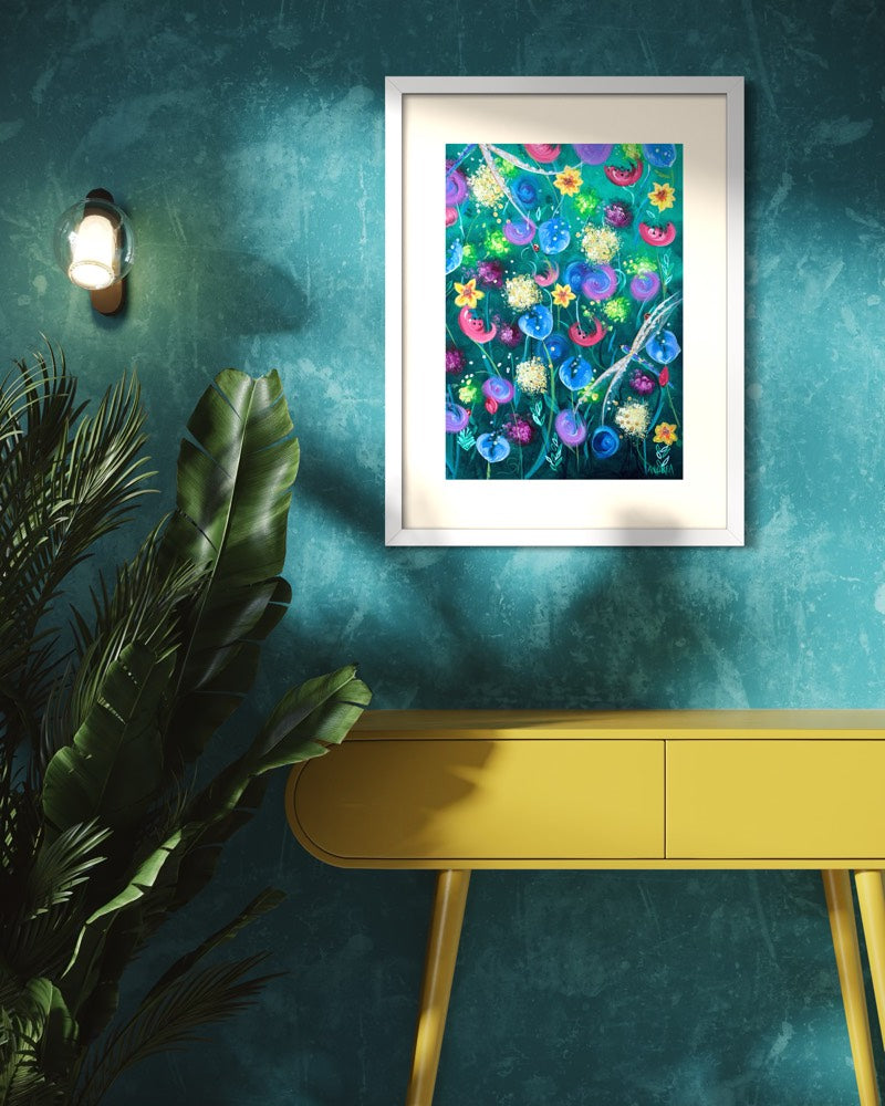 White framed A2 wildflower art print on a teal limewash wall above a mustard yellow console with banana plant fronds and a glass sconce.