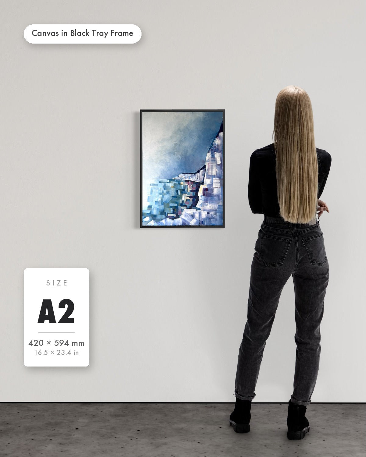 Andrea Nicole 'Solitude' fine art canvas in a black tray float frame, A2 — shown to scale on a gallery wall with a size guide card. | an:family=canvas;role=sizeref;size=A2;finish=black