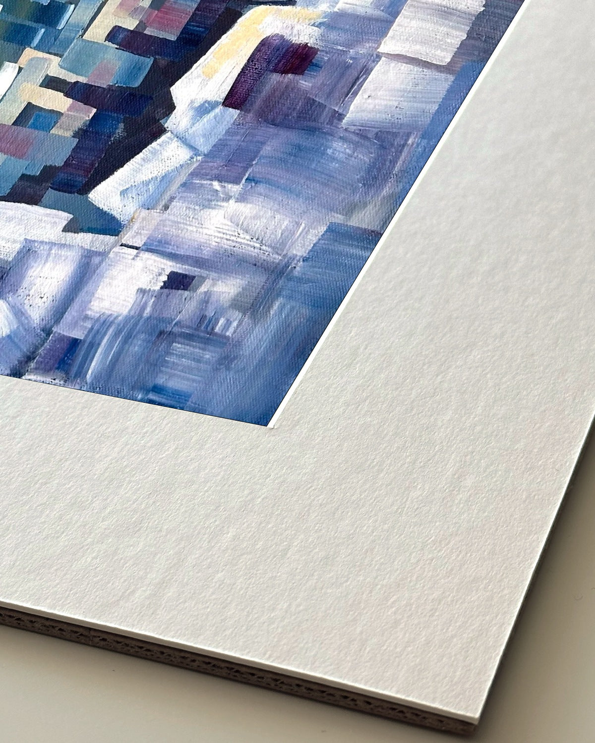 Andrea Nicole 'Solitude' giclée fine art print in an off-white window mount, shown corner-on so the bevel-cut window opening, 100% cotton paper and mount board are visible. | an:family=print;role=mount